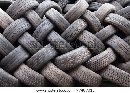 Car tyres stacked in a tyre distribution centre create a herringbone pattern