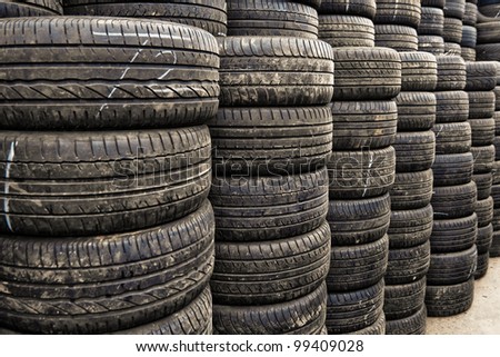 Car tyres stacked in a tyre distribution centre. Selective focus.