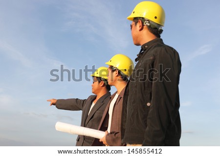 engineer yellow helmet for workers security on the background of a new high-rise apartment buildings and construction cranes and blue sky
