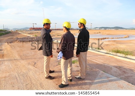 engineer yellow helmet for workers security on the background of a new high-rise apartment buildings and construction cranes and blue sky