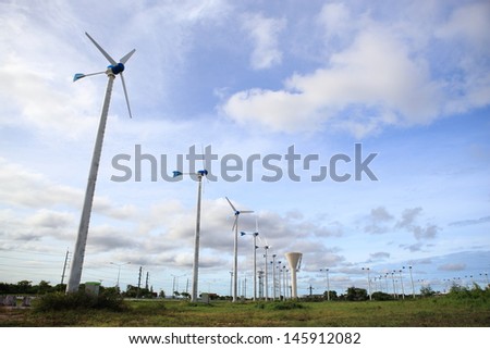 white wind turbine with path generating electricity on blue sky