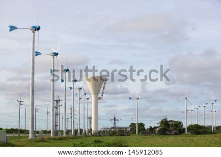 white wind turbine with path generating electricity on blue sky