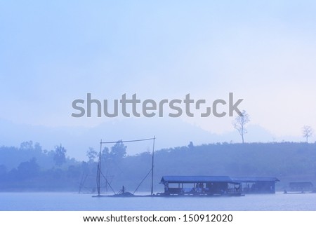 peaceful scene of lake with pier on water at morning with fog