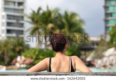 Spa vacation retreat woman relaxing at luxury travel resort. Happy blissful asian young woman in bikini in meditation enjoying summer sun and tanning during holidays .