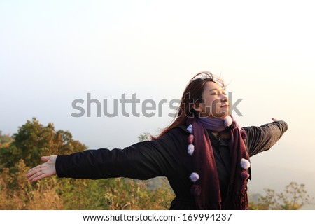 Happy  free woman enjoying nature. Freedom and serenity concept with female model in ecstatic enjoyment. Mixed race Asian Caucasian female model in 40 enjoying outdoor style, north in Thailand