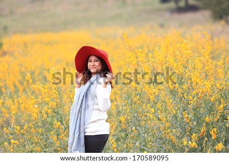 woman happy in free freedom pose with arms raised up towards the sky with smiling cheerful, elated expression of happiness. Beautiful girl in colorful of yellow blossom , flower forest outdoor
