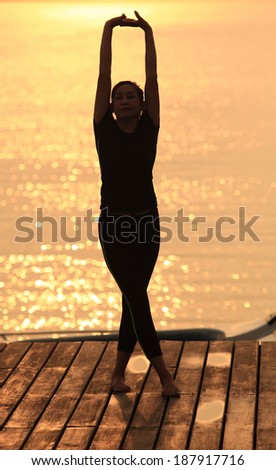Yoga woman in serene sunset . Meditation and balance exercise at sunrise or sunset with female yoga instructor exercising outside in nature.