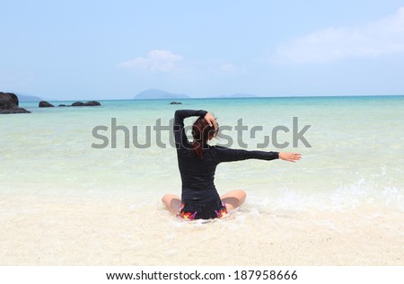 Meditation - Yoga woman meditating at serene beach sunset. Girl relaxing in lotus pose in calm zen moment in the ocean water during yoga holidays resort retreat. Multiracial girl.