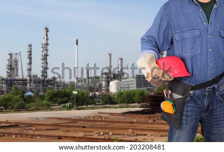 engineer holding red helmet standing in front of site working area