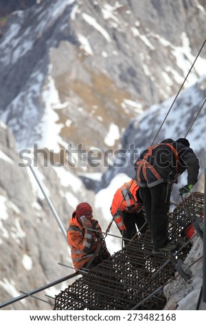 GARMISCH PARTENKIRCHEN , GERMANY  ,  April 16 , 2015 
Mountain working team members in dangerous area ,they are working look like rescue as they evacuate an injured climber from a rock pinnacle.