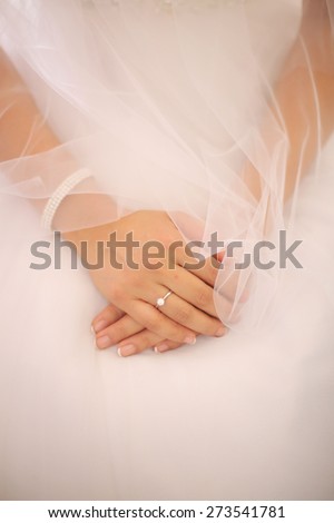 Bride in wedding gown with hands together showing Wedding Ring
