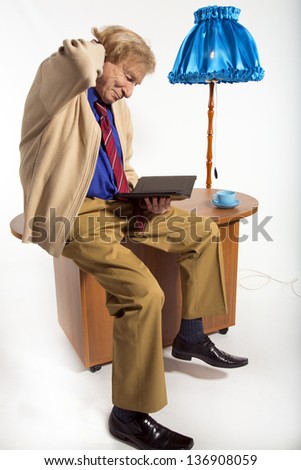 An elderly man on the Internet related to electronic tablet and drinking tea