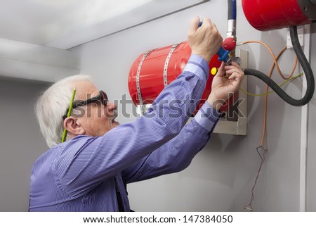Man sets a fixed fire extinguisher