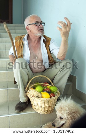 Emotional man sitting on the stairs with a dog and a basket of fruit