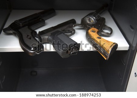 three pistols in the open safe