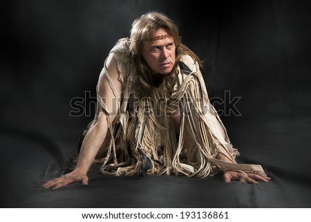 man with long hair in the ancient character posing on a black background