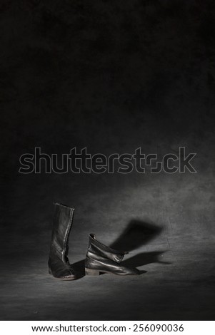 old and dirty military boots in dark studio background