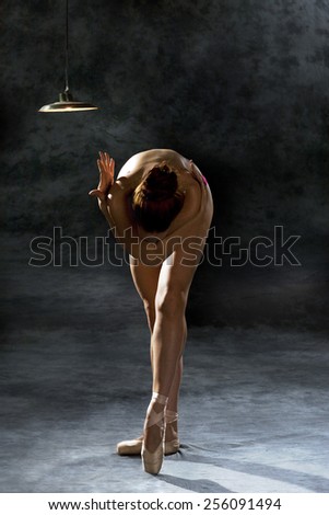 beautiful woman ballet dancer on dark studio background