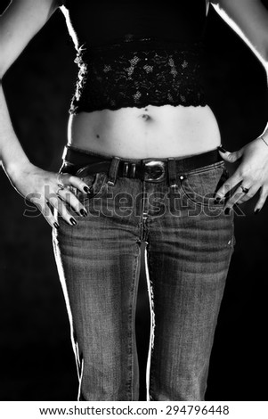 lower body part of slender woman in jeans in black and white colors
