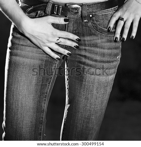 lower body part of slender woman in jeans in black and white colors