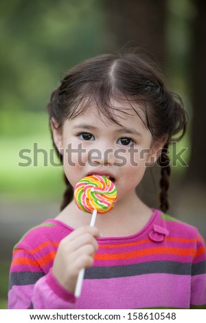 Littler girl eating candy