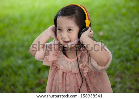 Little girl wear headset to listening music