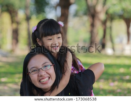 Mother carrying daughter on her back