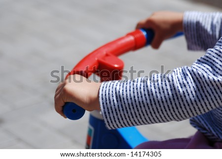 colorful picture of boy riding bicycle. just hands, and bicycle handle.