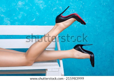 Beautiful female legs wearing high-heeled black shoes