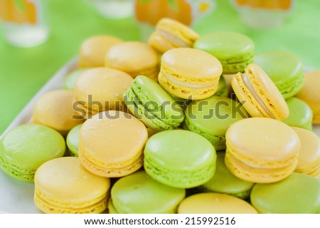 Yellow and green  tasty macaroni cookies on the plate. Candy bar. Children\'s birthday.
