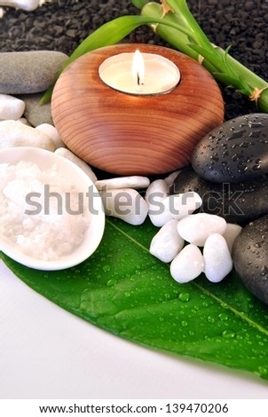 green leaf with natural water drops candles with colored stones