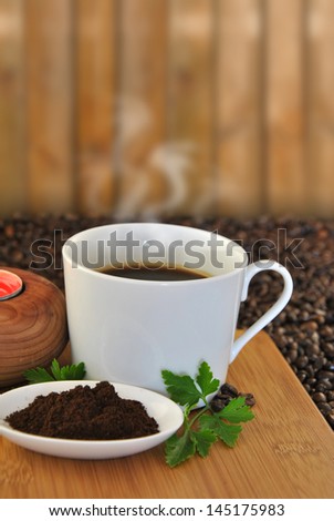 cup of coffee on wood table and coffee beans ground and unground