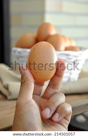 hand picking up a basket egg white wicker
