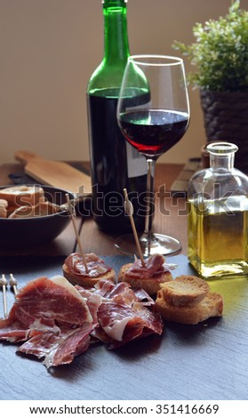 appetizer of ham Serrano with bread roasted and accompanied by a glass of wine