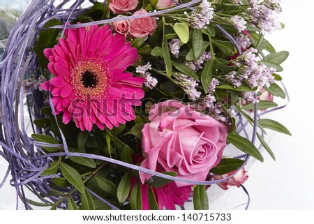 A floral bouquet of roses and a gerbera.