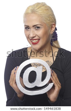 Woman with dark clothes and very fair hair hold a silver at-sign in her hand. The person is exempted on white background.