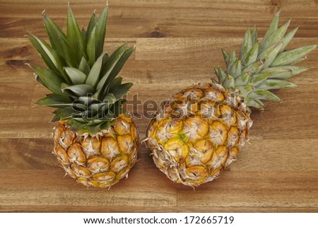 A pineapple is laying on a tabletop of acacia wood.