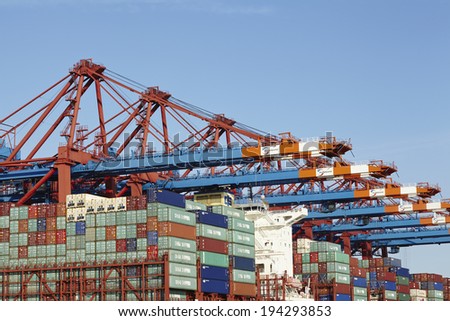 HAMBURG, GERMANY - MAY, 16. Container gantry cranes at the terminal Eurogate in the deepwater port Hamburg-Waltershof are loading/unloading containers of an vessel on May 16, 2014.