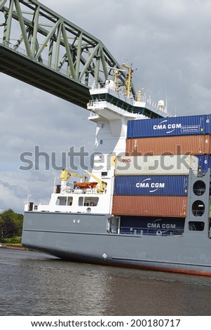 HOCHDONN, GERMANY - JUNE, 15. The container vessel Charlotta B at the Kiel Canal under the railroad bridge Hochdonn (Schleswig-Holstein, Germany) taken in the late afternoon on June 15, 2014.