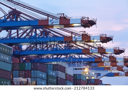 HAMBURG, GERMANY - AUGUST, 8. Container gantry cranes of the terminal Eurogate in the deepwater port Hamburg-Waltershof are loading and unloading a ship on August 8, 2014.