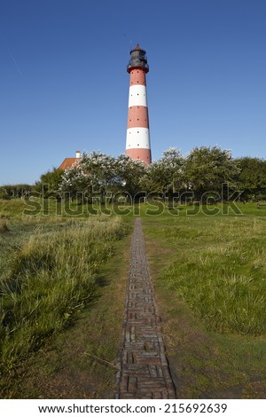Landscape with salt meadows and the light house Westerhever (North Frisia, Germany, Schleswig Holstein) located near the coast of the North Sea taken on a sunny morning.