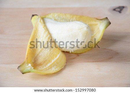 Open banana isolated on wood.