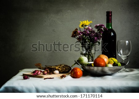 Still life with fish, fruit, vegetables and wine in a silver plate.