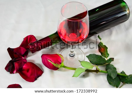 Romantic still life with wine and beautiful red roses.