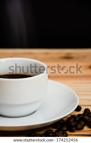 Coffee cup and Rose on a wooden table. Dark background.