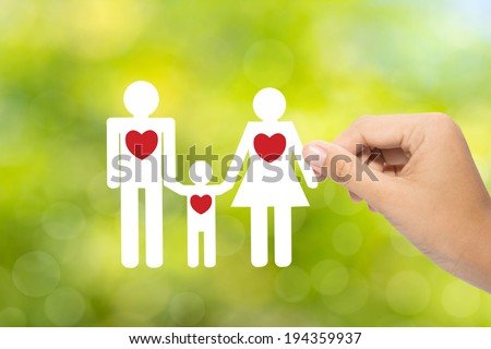 Hand holding a paper family on green background, insurance concept