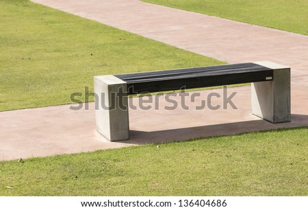 modern stone bench on green grass and stone runway
