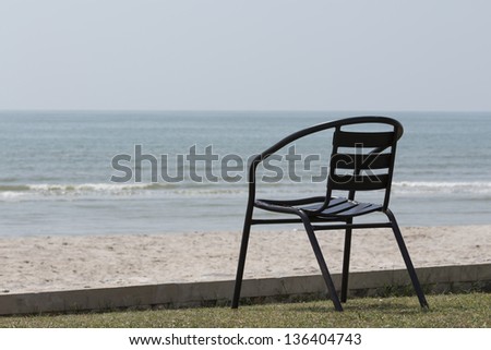 Alone iron chair on green grass and blue sky background