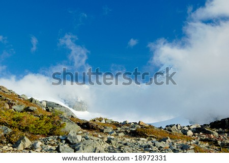 Glacier behind the clouds in the mountain in the early fall