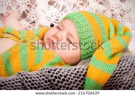 child in striped knitted dress sleeps